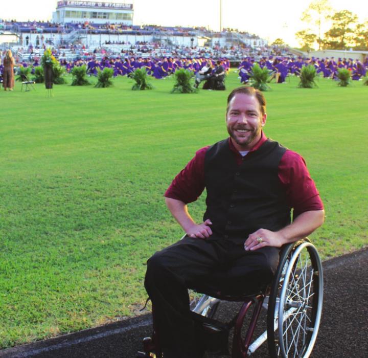 John Comstock, the graduation guest speaker poses for a photo prior to the start of Thursday’s ceremony. He was the last surviving student to be pulled out of the 1999 Texas A&amp;M bonfire collapse that killed 12 and injured 27 students.