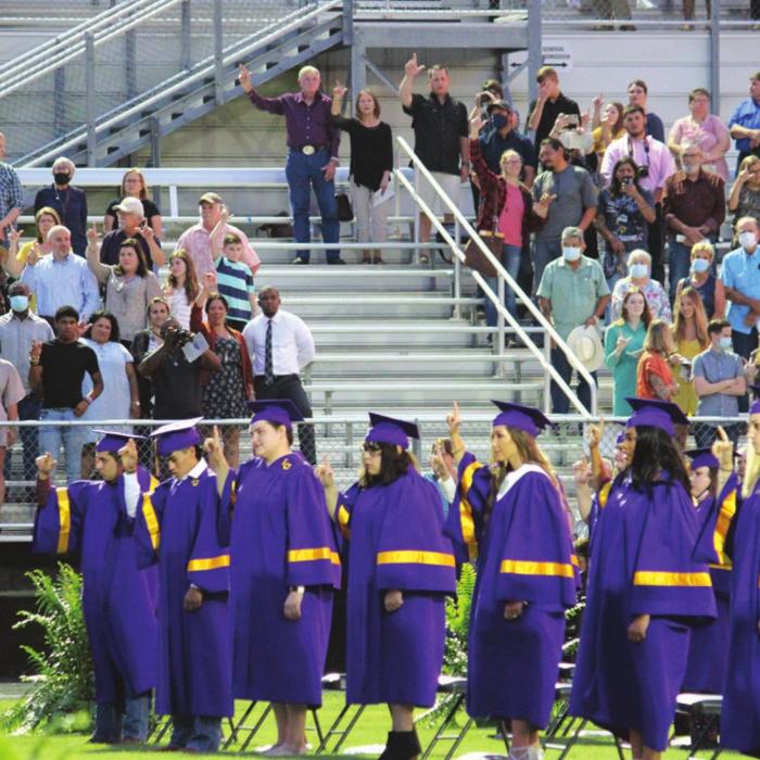 La Grange graduates sing the school song as attendees (groups of 10 or less for each grad were spaced apart) look on.