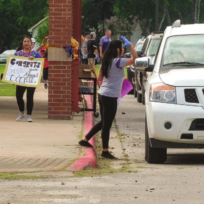 Seniors at La Grange High School picked up their graduation caps and gowns in a drive-through at the school Tuesday, May 5. For most of the students, it was their first visit to campus since spring break, when the school closed for the coronavirus. At the drive-through on Tuesday, teachers and school staff held up motivational signs for the soon-to-be graduates. La Grange ISD has not yet announced plans for a graduation ceremony. Seniors were told to expect a ceremony date in June. Photo by Andy Behlen