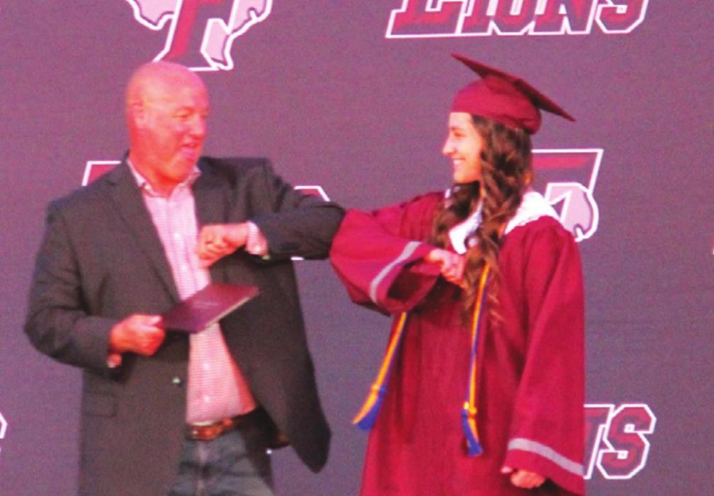 Fayetteville superintendent Dr. Jeff Harvey gave elbow bumps to each graduate (here Julie Korenek) instead of handshakes as they came up on stage to get their diploma. Photo by Jeff Wick