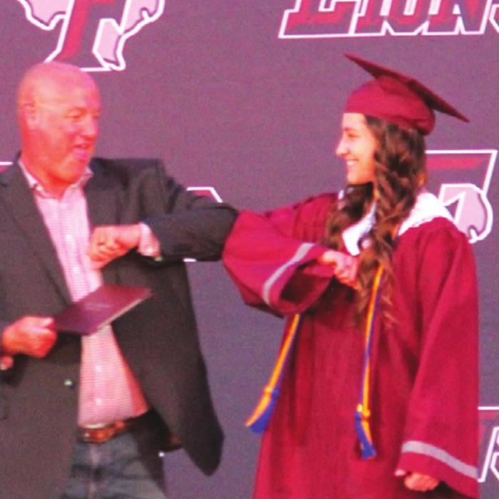 Fayetteville superintendent Dr. Jeff Harvey gave elbow bumps to each graduate (here Julie Korenek) instead of handshakes as they came up on stage to get their diploma. Photo by Jeff Wick