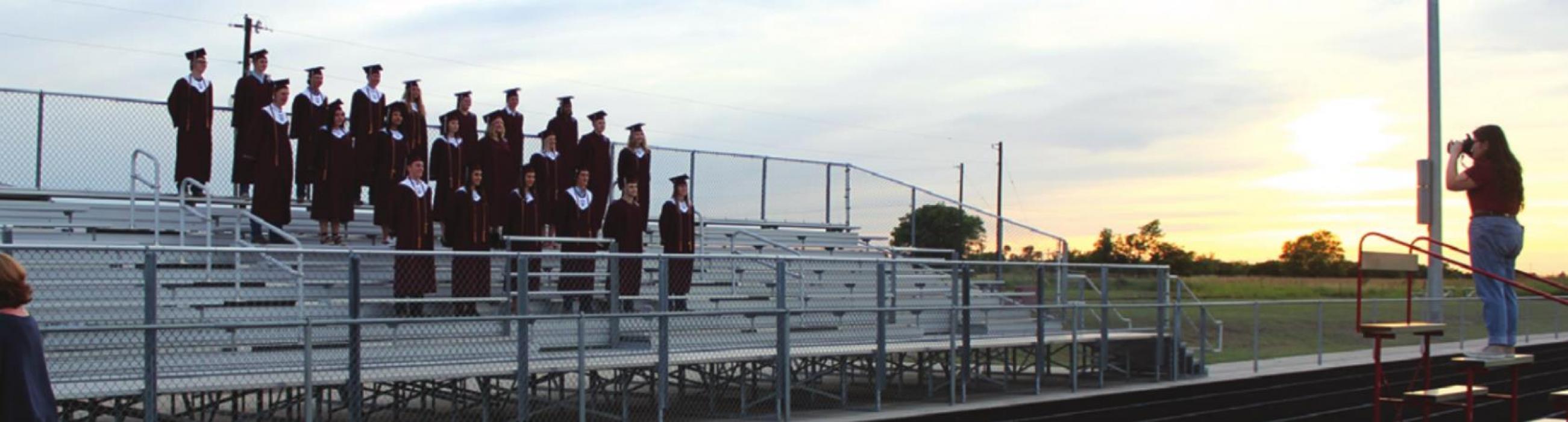 As the sun sets, Grace-Anne Matocha takes a group photo of the Fayetteville seniors before the ceremony.