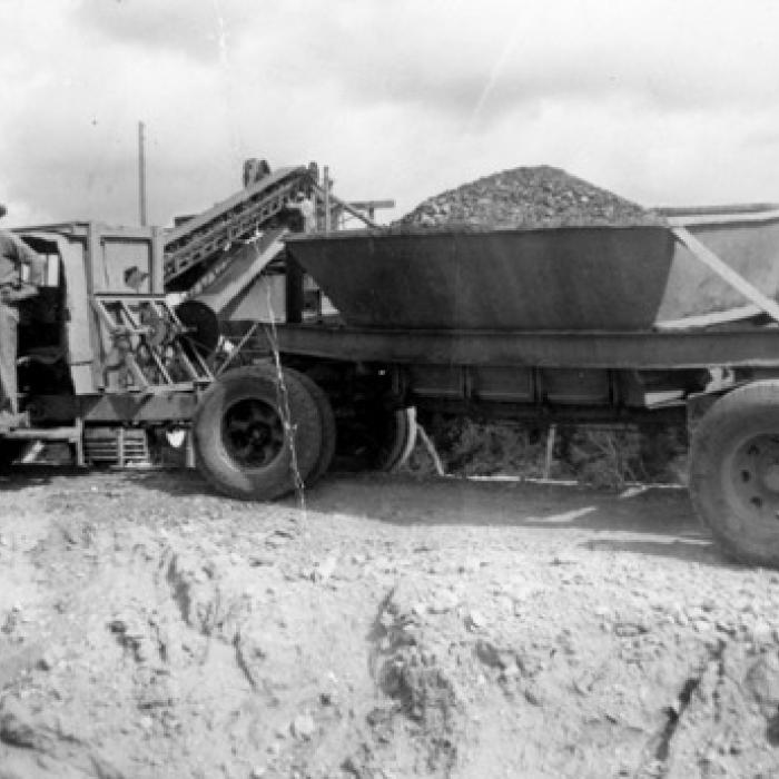 Photograph of an unidentified man standing on the running board of a gravel truck. Photo courtesy of the Fayette Heritage Museum and Archives