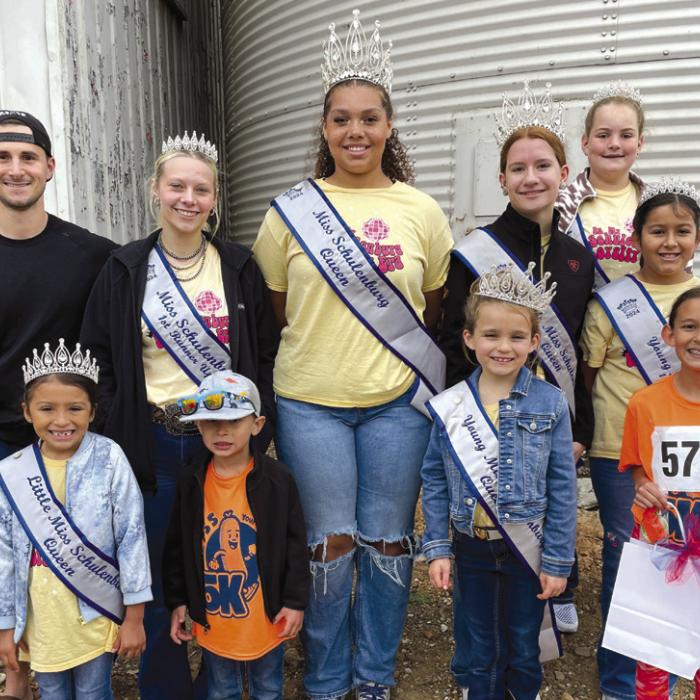 Pictured are 5K winners Laine Brown (on the far left in the dark sweatshirt) and Emma Zweschper (on the far right in the front row). They are pictured with Schulenburg Festival royalty, who volunteered to work the water station at the halfway mark of the 5K.