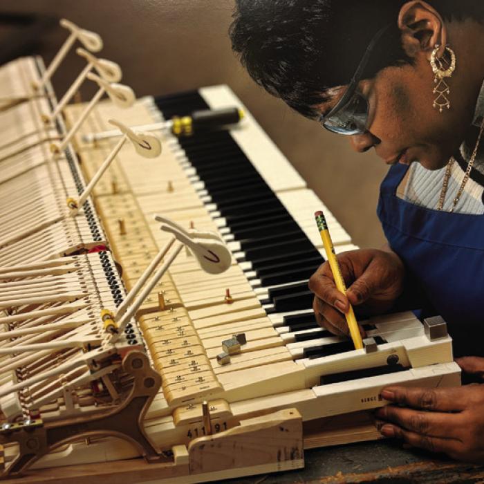 Steinway employee Gwendolyn Folk balancing keys. Photo by Christopher Payne