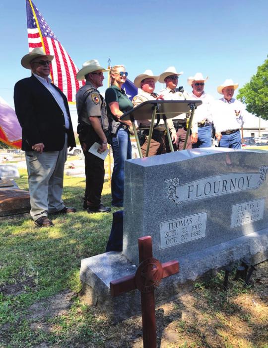 The new memorial cross stands in the foreground in from of T.J. Flournoy’s tombstone as several local dignitaries pose for a photo after Saturday’s ceremony. From left, State Rep. candidate Stan Kitzman, Deputy Michael Krenek, Sgt. Angela Lala, Sgt. Charles Jobb, Deputy Terry Guentert, Fayette County Sheriff &amp; former special Texas Ranger Keith Korenek, and Chief Deputy Randy Noviskie. Photo by Elaine Thomas