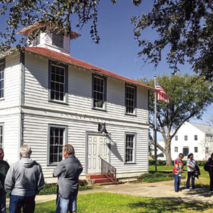 Attendees stand outside the Round Top Precinct Courthouse before a recent meeting. Record file photo