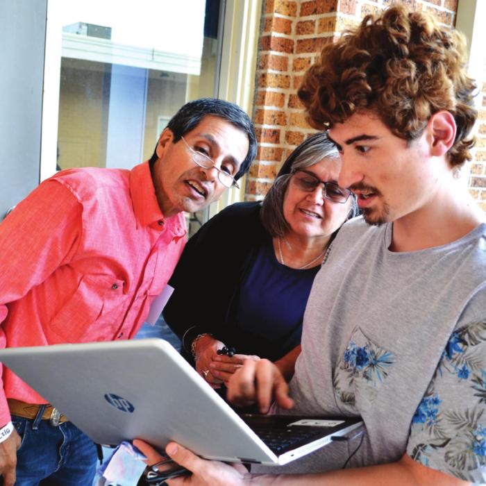 Nicolas England explains the ins and outs of Linux to new computer owners Maria and Juan Guajardo. Photos courtesy of Bill Bishop
