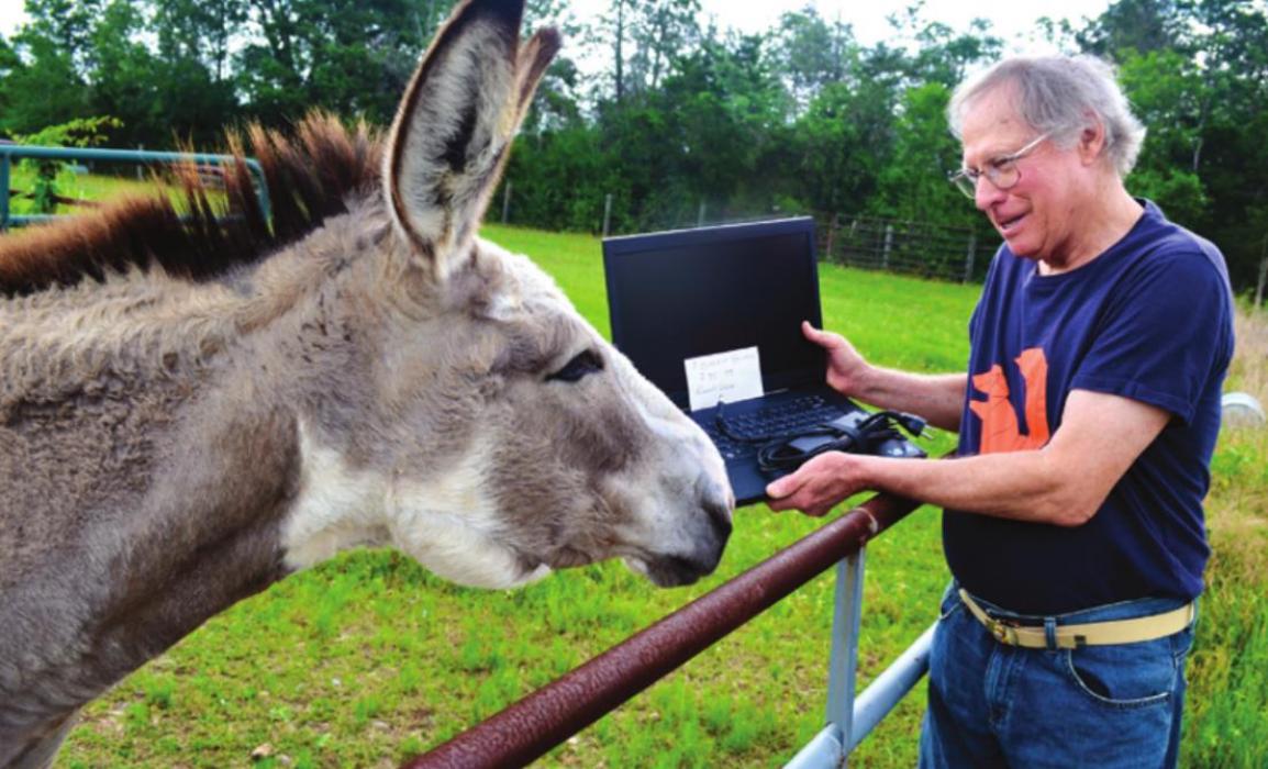 Bill Rose shows one of the old computers he loaded with Linux to his mule.