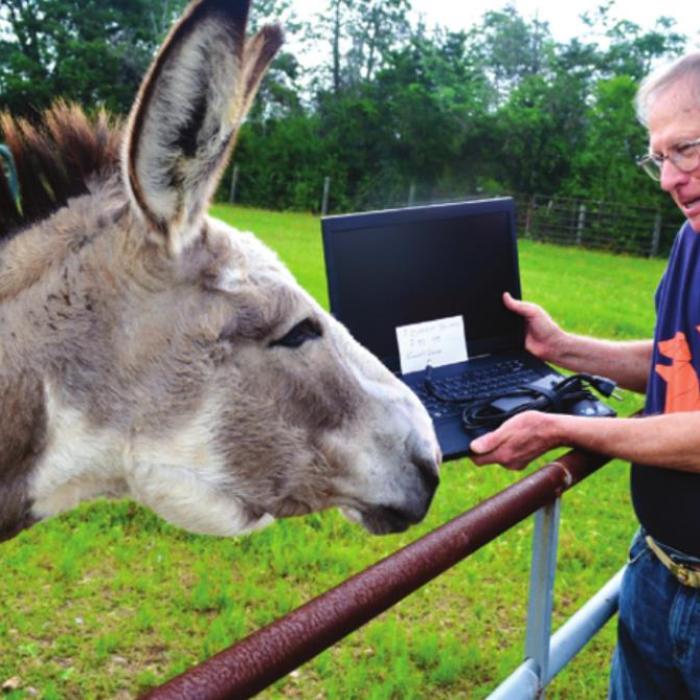 Bill Rose shows one of the old computers he loaded with Linux to his mule.