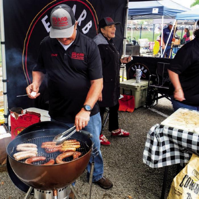 Tracy Ebarb of Ebarb Craft Sausage grills some of his company’s famous links at their booth during last year’s Sausagefest. Record File Photo