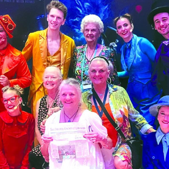 Joyce Schramek of Schulenburg (standing, center) celebrated her 90th birthday on a cruise aboard the Carnival Dream with three of her four daughters. Pictured are center bottom from left are Lorie Kutach, Karen Ross holding a copy of The Fayette County Record, and Debra Blansitt. A tour of Belize City was enjoyed.