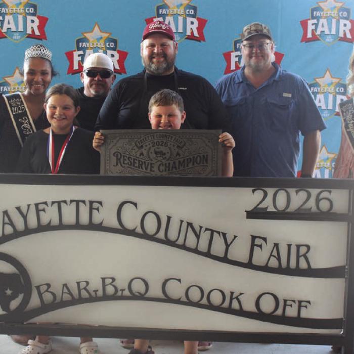 The team of Good and Ready won reserve champion and first place pork butt at Saturday’s Fayette County Fair Bar-B-Q Cook Off. Left to right, 2025 Jr. Miss Fayette County Anabelle Zwahr, 2025 Queen second runner-up Keanna Henderson, Lillian Tofel, Tiger Hall, head cook David Tofel, Frank Tofel (holding banner), Michael Tofel and 2025 Fair Queen Hailey Janish.