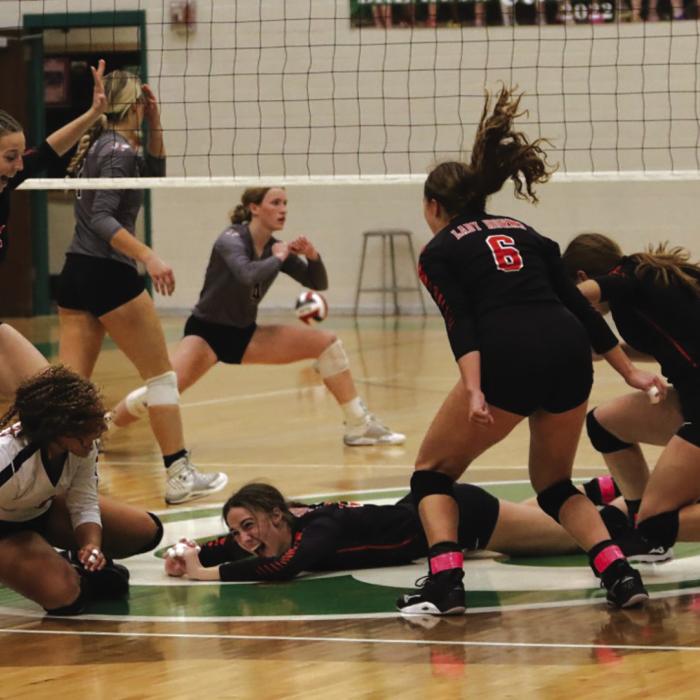 Schulenburg’s Meredith Magliolo, center, lays on the ground as her teammates circle around her after she hit the final point to clinch the regional championship over Johnson City Saturday, sending the Lady Horns to the state volleyball tournament. Photo by Audrey Kristynik