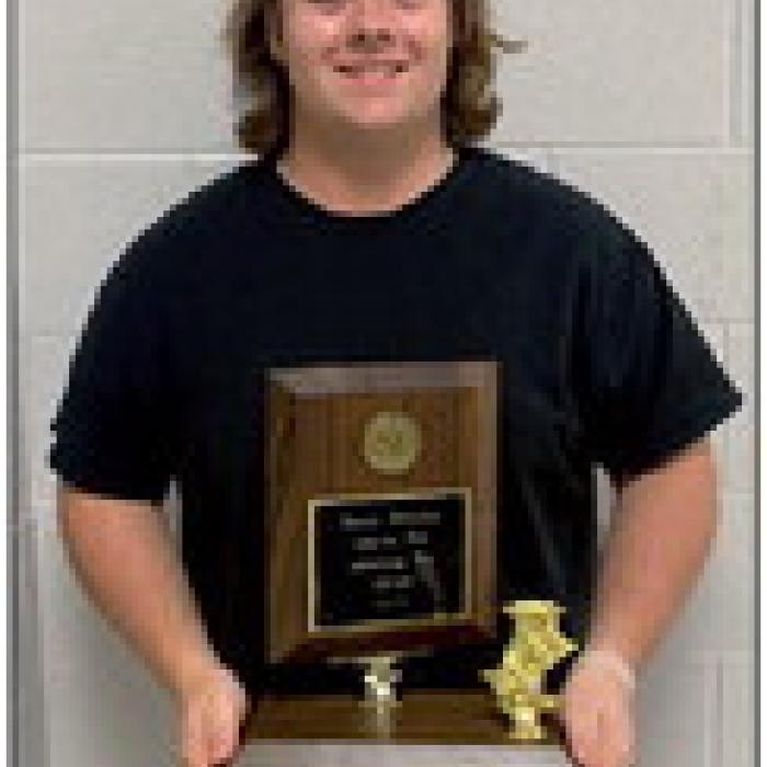 Austin Williams, Honorable Mention/Acting, holding the trophy for the play advancing