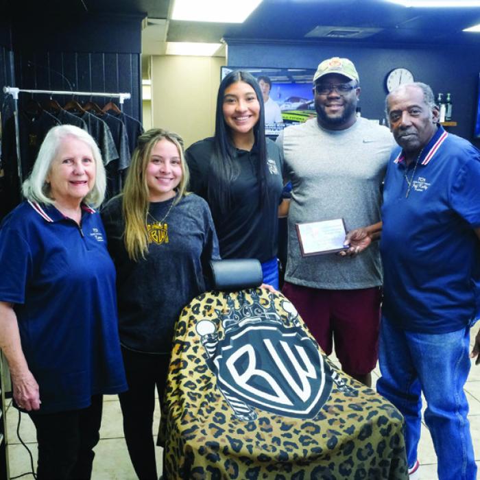 The local nonprofit Fayette County Helpers presented a plaque of appreciation to the Brian Williams Barbershop for providing more than 100 free haircuts to students heading back to school this year. Pictured are (from left) Karen Forest of Fayette County Helpers; Jayde Manasco, Citlalli Barcenas and Brian Williams of Brian Williams’ Barbershop; and Jeff Kelly of Fayette County Helpers. Photo by Andy Behlen