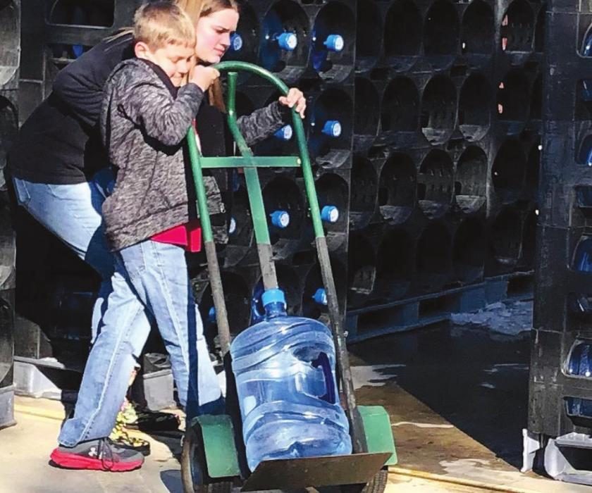 Young volunteers helped unload 240 five-gallon jugs of water supplied by the Fayette County Office of Emergency Management. Pct. 1 Commissioner Jason McBroom delivered the water. Residents on the bluff have been without running water for over a week after the extreme cold weather last week froze and busted water pipes.