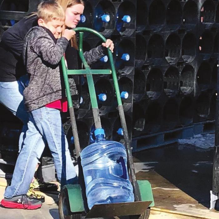 Young volunteers helped unload 240 five-gallon jugs of water supplied by the Fayette County Office of Emergency Management. Pct. 1 Commissioner Jason McBroom delivered the water. Residents on the bluff have been without running water for over a week after the extreme cold weather last week froze and busted water pipes.