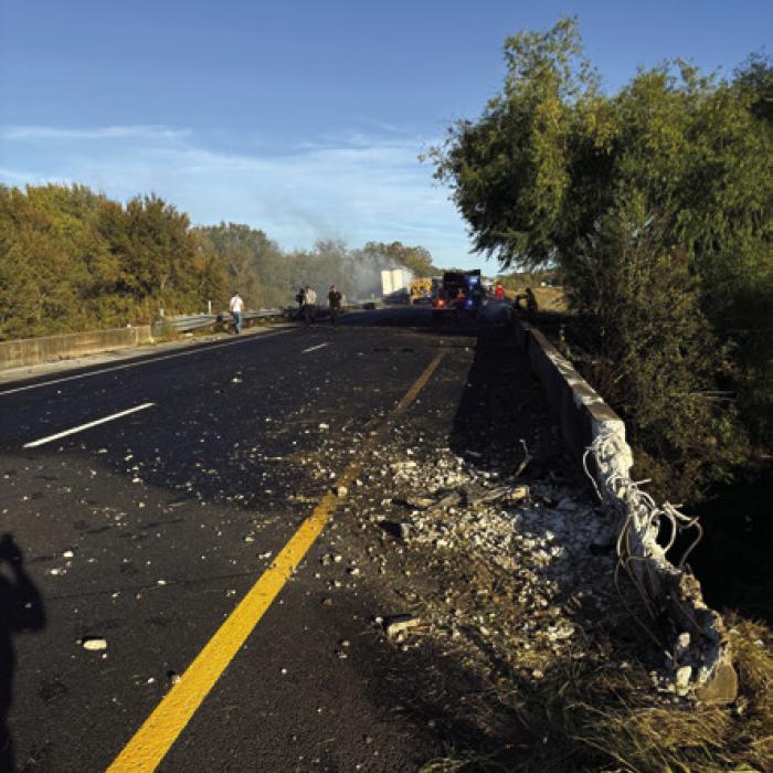 Left, Schulenburg firefighters work to extinguish a burning 18-wheeler on Interstate 10 Sunday. Right, damage to the guardrail shows where the 18-wheeler crossed the Interstate, just barely avoiding a plunge down into Middle Creek. Amazingly, it traveled all the way down the bridge in the way of oncoming traffic without hitting any other vehicles. The rig eventually crashed in the ditch and caught fire. The driver was able to escape without injury. Photos courtesy of Schulenburg VFD