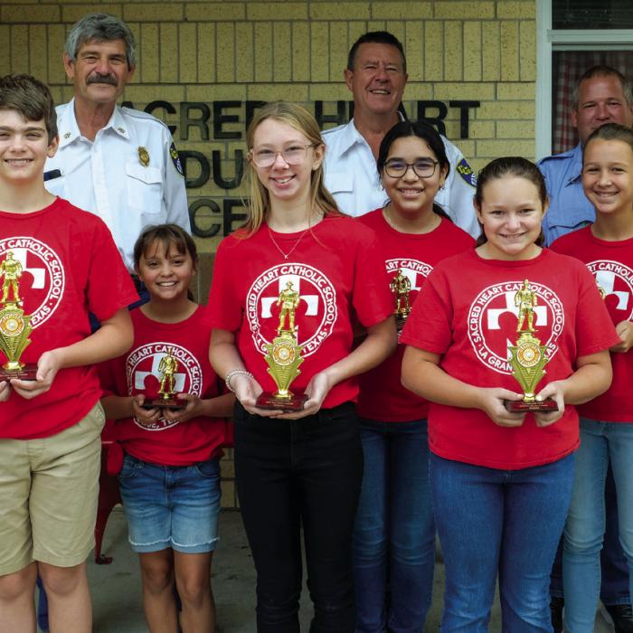 Winners of the fire poster contest for Grades 5-6 at Sacred Heart School went to (front, from left) Aiden Harbers, Kenlie Jo Kallus and Hannah Garza. Honorable mention winners were (middle row) Camille Fabre, Eliana Anzaldua and Lyla Cowen. Pictured with them are (back) Asst. Chief Frankie Srubar, Fire Chief Frank Menefee and Capt. Kenneth Chovanec of the La Grange Volunteer Fire Department.