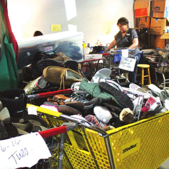 Above and below, volunteers at Second Chance Emporium have been working hard to process and sanitize the mountain of donations that have been coming in, but they can’t keep up – and even their new larger facility can’t hold them all. Photos by Jeff Wick