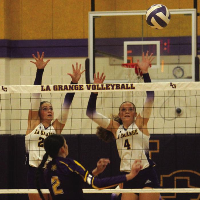 La Grange’s Kyndal Brawley, left, and Avery Griffin, right, jump to try to block a Weimar hit in Tuesday’s win. Photo by Jeff Wick