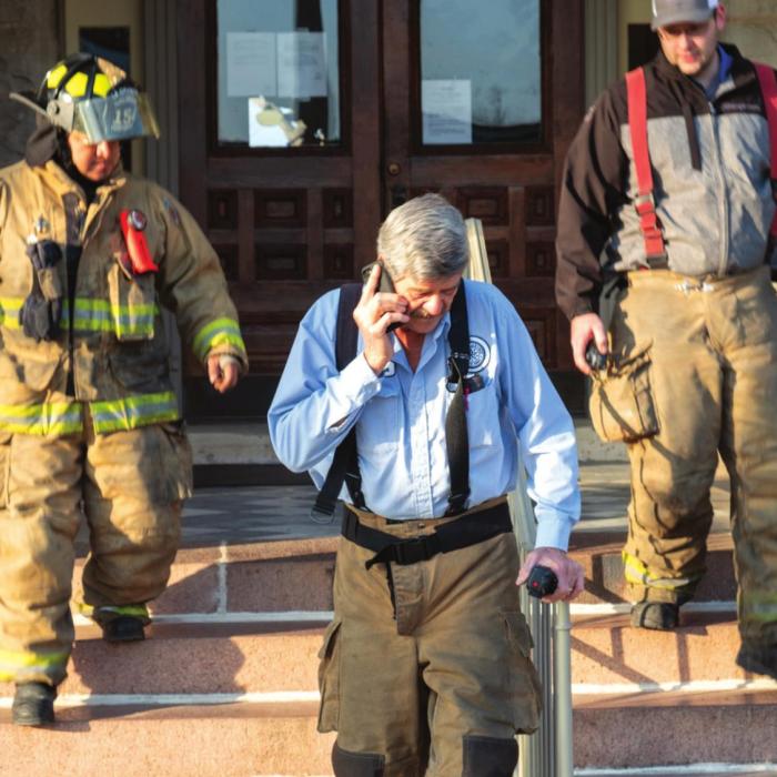 La Grange Assistant Fire Chief Frankie Srubar (center) leads a team of firefighters out of the courthouse Monday morning after checking for a gas leak. County leaders evacuated the courthouse that morning after noticing a strong smell of natural gas. The smell turned out to be associated with some work on a natural gas line at the new Business 71 river bridge. Photo by Andy Behlen