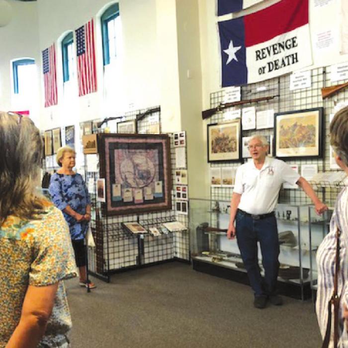 Docent Charles Murray explains the signifi cance of wall items to Fayette County Retired Teachers.