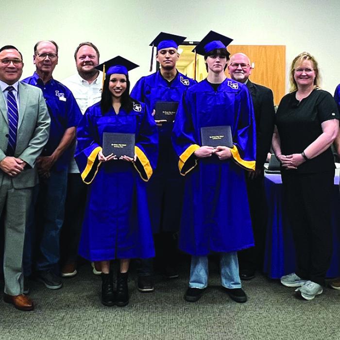 Left to right at Monday’s graduation ceremony – Superintendent Andy McHazlett, high school assistant principal Nathan Truex, high school principal John Pineda, board members Calvin Mersiovsky and Anthony Wessels, graduates Camryn Alvarado, Silvestre Lara-Villegas and Trevor Flood, board members Gary Drab and Karen Roberts, Leopard Academy instructor Brad Harbers and high school counselor Charlee Hernandez. Photo by Regina Keilers
