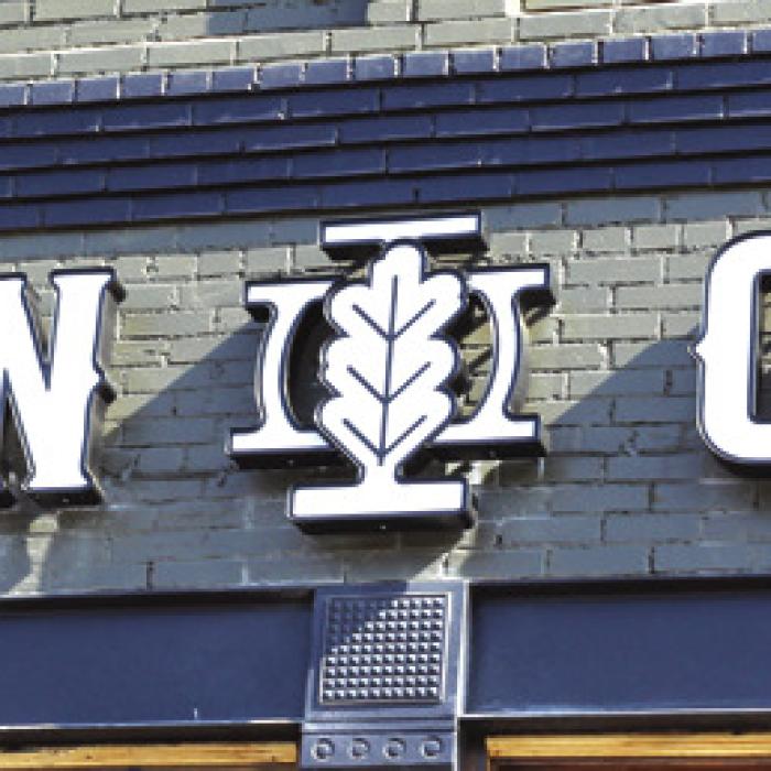 Above: A trio of Schulenburg grads, and their families celebrated the grand opening of Iron Oak Apparel in downtown Schulenburg earlier this month. Right: The sign on their business 635 N. Main Street. Photos by Jessica Montez