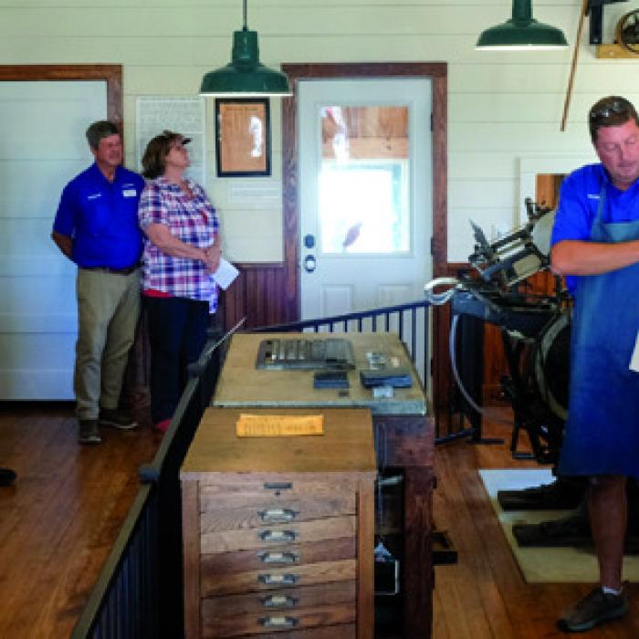 Mark Hermes demonstrates printing inside the newspaper museum on the grounds of the Texas Czech Heritage and Cultural Center Saturday.