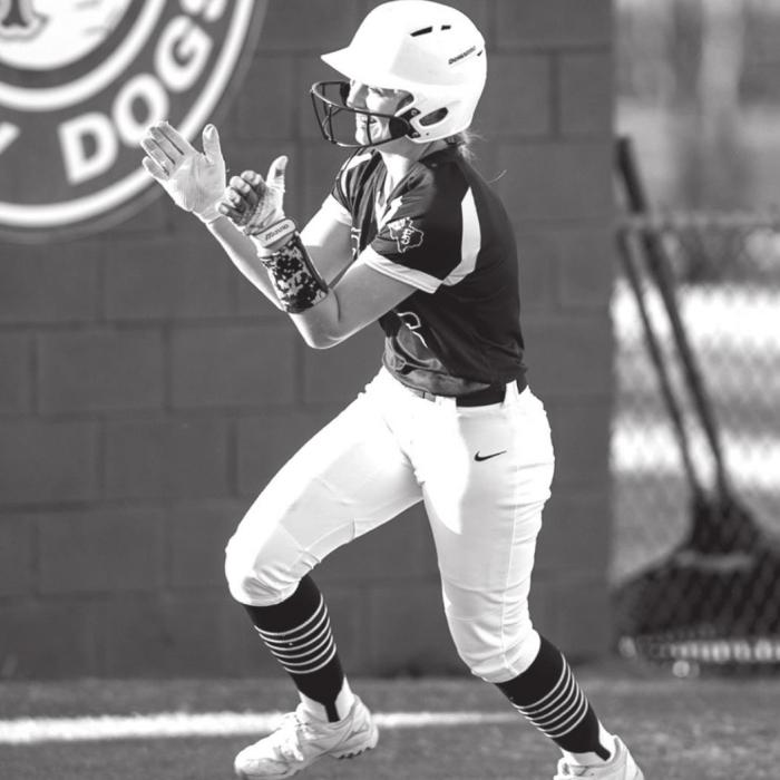 Abby Drabek celebrates her second homerun for the week as she rounds third heading to home plate where her team mates are gathered to greet her. Photo by Stephanie Steinhauser