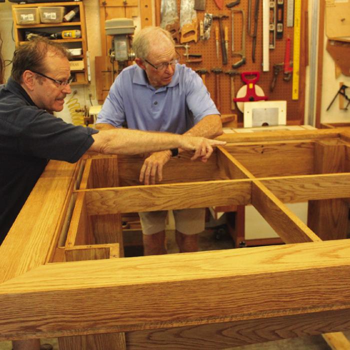 Father Eddie Winkler, left, chats with Bob Stanzel, right, as they examine the altar Stanzel is building for the new Hostyn Catholic Church. Photos by Jeff Wick