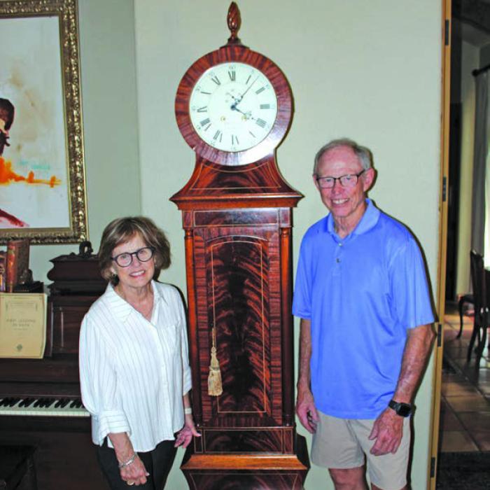 Bob Stanzel and his wife Lucy pose next to a grandfather clock Bob built at their home in La Grange. Next Bob has turned his attention to building a new altar and ambo for the Hostyn Church, which was destroyed by a gas explosion in 2022. Photo by Jeff Wick