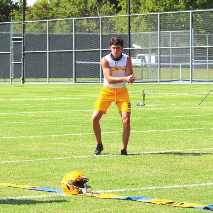 Masked La Grange football coach Matt Kates works Monday with Caden Cooper and Matthew Johnson, returnees, who split time at quarterback last season.