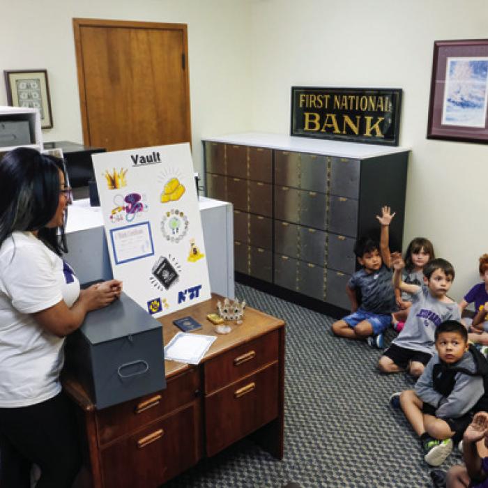NBT’s Traye Wright shows the students what kinds of valuable items people store in safety deposit boxes. Photos by Andy Behlen