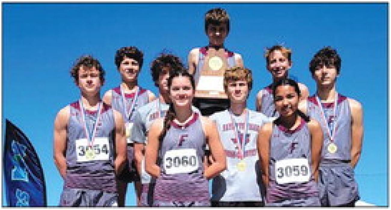 The Fayetteville cross country team holds up their Region IV-1A boys team title trophy.