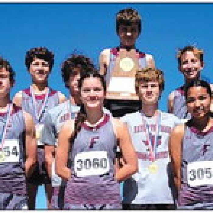The Fayetteville cross country team holds up their Region IV-1A boys team title trophy.