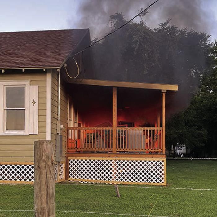 La Grange Police Officer Noah Geer with the help of local pastor Will Martin put out this porch fire with a water hose last Friday.