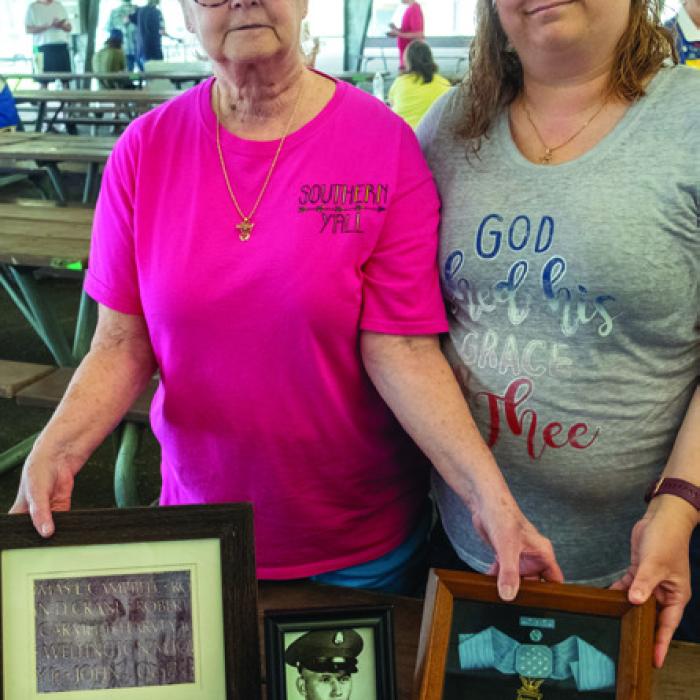 Frances Seymour (left) and her daughter Stacey Krenek (right) brought along the Medal of Honor awarded posthumously to Seymour’s brother, Carmel Vernon Harvey Jr., who gave his life at Binh Dinh Province, Vietnam, on June 21, 1967. They are hold the Medal of Honor and an image of Harvey’s name etched into the Vietnam War Memorial in Washington D.C.