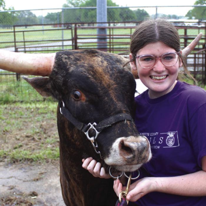 Jaden Melton of La Grange gives her longhorn Betty a hug while getting her prepped for the show Friday. Jaden’s dad said they had to get special permission to show a longhorn here, and he was told this was the first-ever longhorn shown at the Fayette County Show. Jaden was able to purchase Betty after catching a calf in the scramble at the Fort Worth Stock Show.