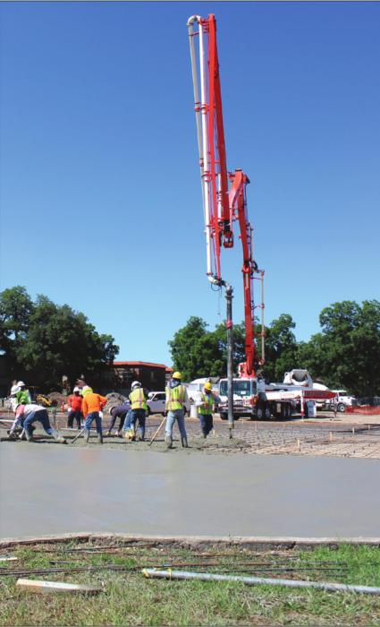 Several people were hard at work Monday smoothing out a steady stream of concrete in the new school parking lot on the corner of Vail and Jackson Streets in La Grange. Photo by Jeff Wick