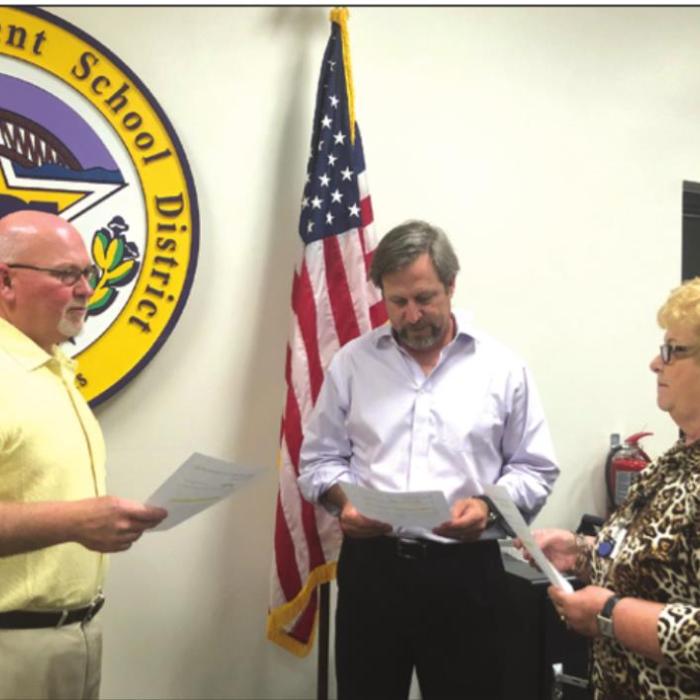Nora Otto conducted the swearing in ceremony for Gary Drab, left, and Marc Fitzpatrick, center at Monday night’s school board meeting. Photo by Regina Keilers