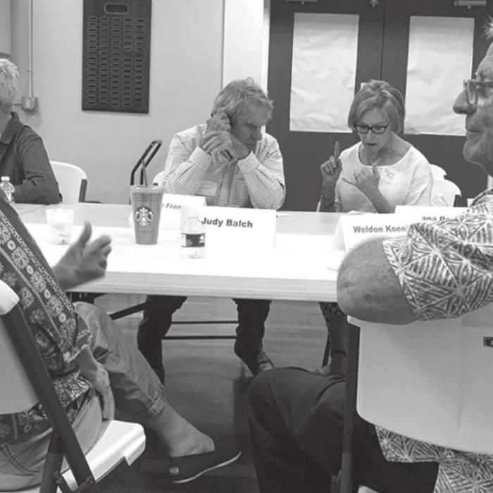 Judy Balch and Weldon Koenig discuss their differing views, while in the background, George Frondorf and Dianna Berg do the same.