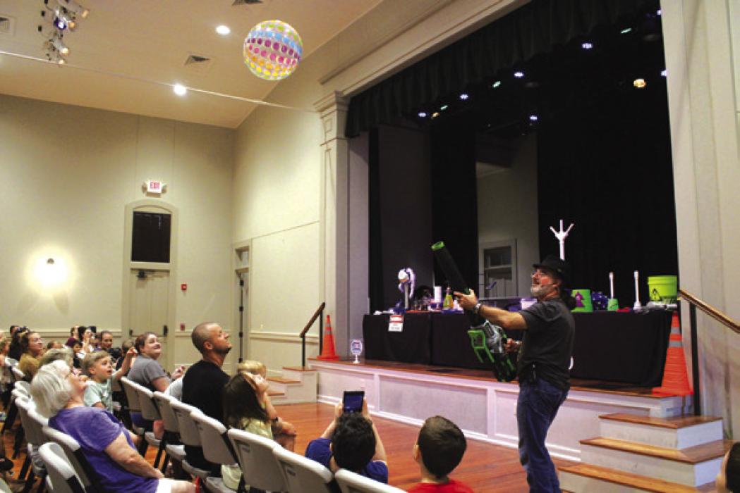 Above, Daniel Benes creates a fiery reaction during one of his tricks at Casino Hall as part of Fayette Public Library’s Summer Reading Program. Right, Benes creates a vacuum with a leaf-blower and projects a beach ball steadily up into the air. Library will be hosting its “Summer Reading Party in the Park” for children and families who participated in the summer reading program on Thursday, July 27 from 5-7 p.m. on the Library’s lawn. Photos by MaKenzie Givan