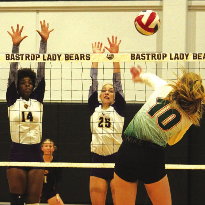 La Grange’s Tori Harold, left, and Kylie Trlicek, center, jump to block a hit by Gateway Prep’s Addie Brown. Photos by Jeff Wick