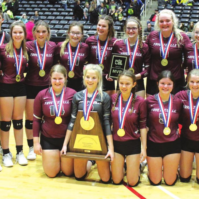 The members of the Fayetteville volleyball team pose with their title trophy and gold medals on the court at the Culwell Center in Garland after winning the 1A state title Thursday. Photo by Jeff Wick