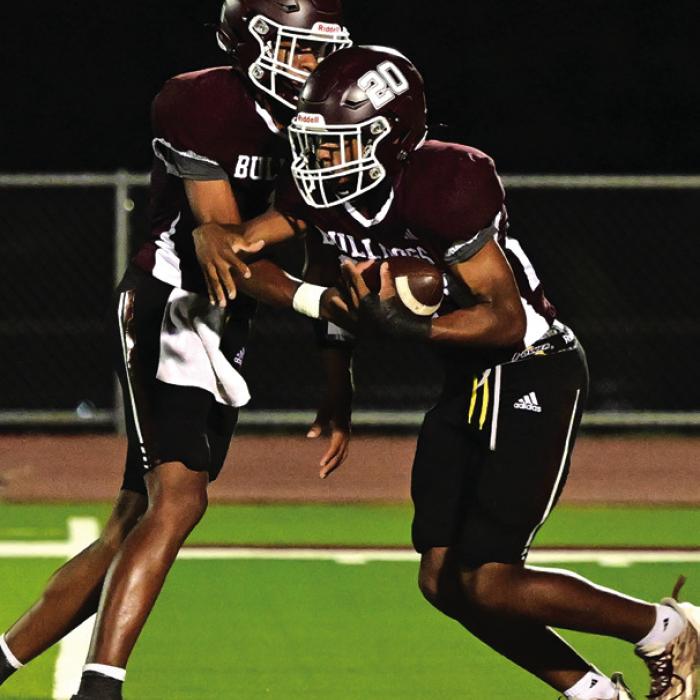 Flatonia quarterback Jaylon Anderson hands the ball off to his younger brother Adrian last season. Both Andersons are back for the Bulldogs this season. Photo by Stephanie Steinhauser