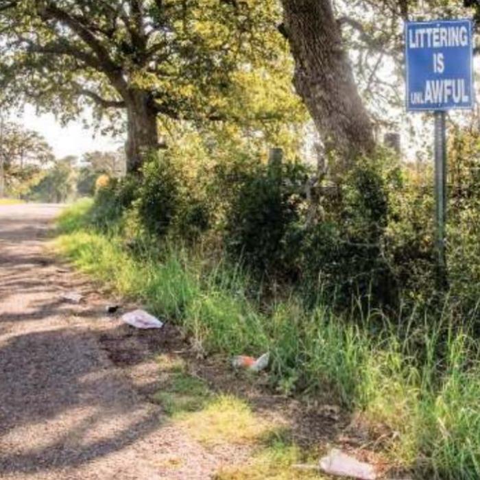 Someone recently tossed their Whataburger garbage onto the side of Rocky Creek Road in front of a littering sign. Photo by Andy Behlen