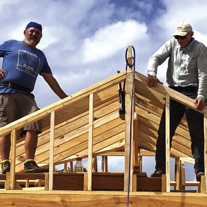 The vision of a warm and welcoming future is rapidly becoming reality for Johnny Wright, a devoted father to four children—Demarion (18), Billy (10), Sam (7), and Julie (5) who have partnered with Habitat for Humanity to build a better future. The family, currently living in a two-bedroom apartment, will soon move into the above spacious new home, with Habitat volunteers shown here, Executive Director Kenny Couch, left, and Norman Wied, right.